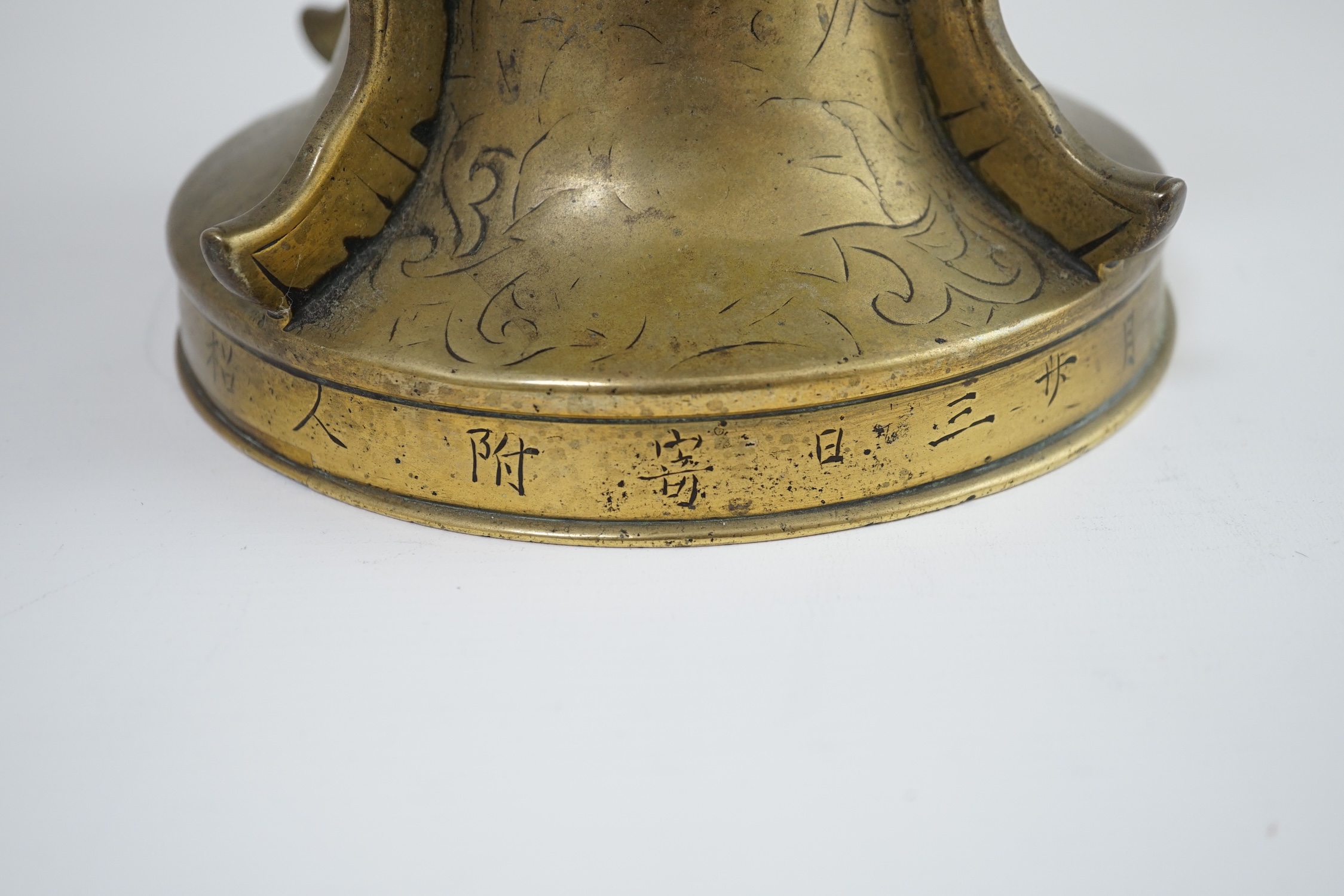 A Chinese inscribed archaistic bronze altar vase, gu, 19th century, the foliate engraved vase applied with raised fins and cast in relief with lion-dogs, the base engraved with an inscription, 33.7cm high. Condition - go